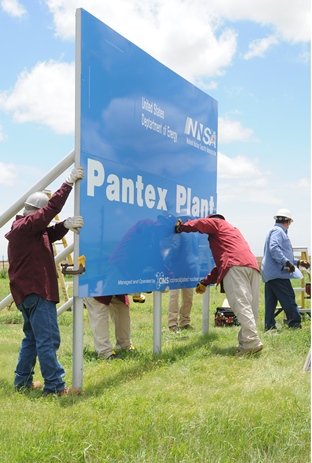 Workers put up a new entry sign at the Pantex