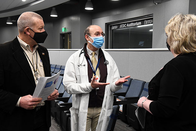 Dr. Paston (center) talks to Geoff Beausoleil, manager of the NNSA Production Office, and Michelle Reichert, CNS president and chief executive officer, at the vaccination clinic.