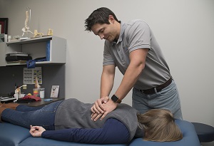 Pantex physical therapist Cody McClary applies pressure to a patient’s back to help alleviate discomfort.
