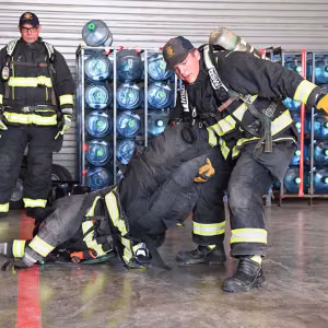 Firefighters Hunter Holman and Zach Ayala demonstrate one method to carry a downed firefighter.
