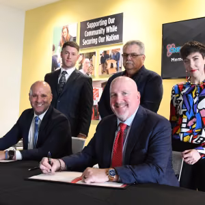 TEMU Thomas Phillips (front row, from left) and Pantex Deputy Site Manager Kenny Steward sign a memorandum of understanding